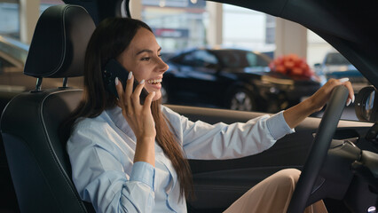 Happy Caucasian successful businesswoman talking mobile phone call friendly conversation joyful woman sit in new car in automobile shop rent service renting buying auto luxury vehicle speak smartphone - obrazy, fototapety, plakaty