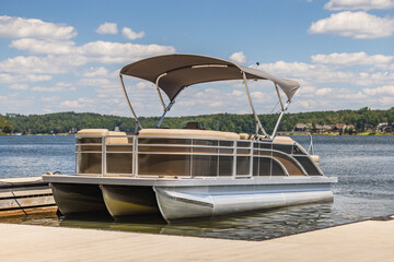 Pontoon boat at private marina dock on freshwater lake.