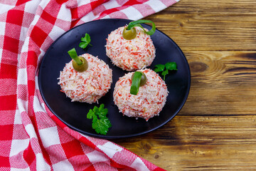 Appetizer of crab-cheese balls made in a shape of Christmas baubles on wooden table