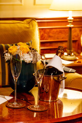 Champagne bottle in an ice bucket with two champagne glasses