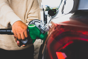 Man's hand holding a gasoline dispenser refuel yourself