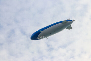 Naklejka na ściany i meble Blimp, airship or dirigible flying in sky