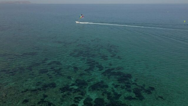 Motor boat tows a special parachute in the sea.