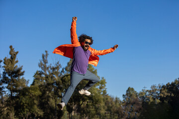 Mexican with beard jumping in the air in a free and surprise position