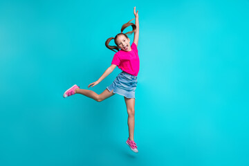 Full size photo of funky pleasant girl dressed pink t-shirt jeans skirt flying raising arm up isolated on turquoise color background