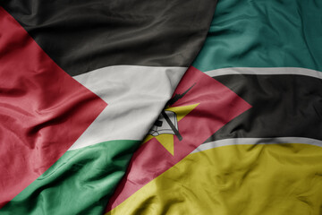 big waving national colorful flag of mozambique and national flag of palestine .