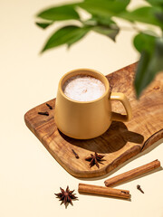 Masala tea. Traditional Indian drink with a mixture of spices and herbs. A yellow mug with a frothy...