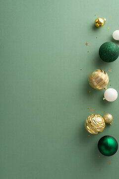 Sleek holiday ambiance. Overhead vertical image featuring set of lavish baubles, and sparkling gold sequins on a mint green surface, providing an open area for personalized messages or advertisements