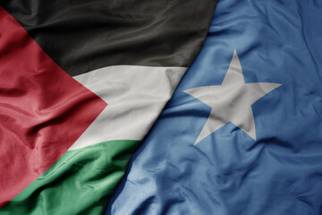big waving national colorful flag of somalia and national flag of palestine .