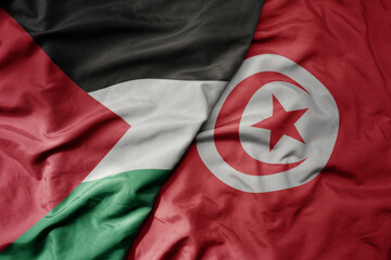 big waving national colorful flag of tunisia and national flag of palestine .