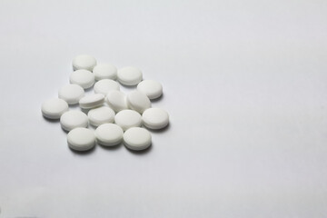 Assorted white pharmaceutical pills on a pristine background, perfect for health and medication themes.