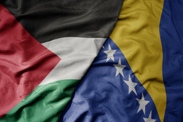 big waving national colorful flag of bosnia and herzegovina and national flag of palestine .