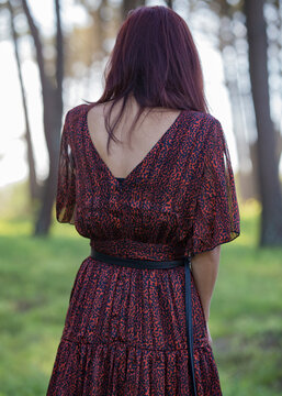 Detalhe de mulher de costas com decote no vestido vermelho e preto.