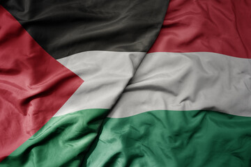 big waving national colorful flag of hungary and national flag of palestine .