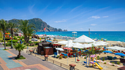 Fototapeta na wymiar Beautiful Alanya with comfortable beach, green palm trees and blue sea in Antalya Province, Turkey