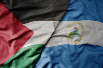 big waving national colorful flag of nicaragua and national flag of palestine .