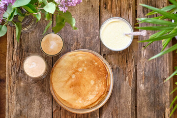 crepes with mascarpone sauce and condensed milk. Top view. Wooden background.