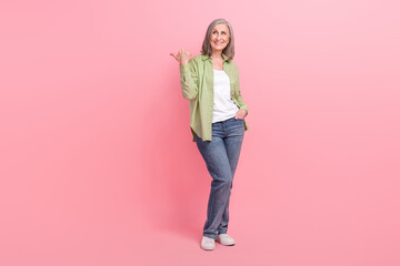 Full length photo of lovely satisfied lady wear stylish clothes presenting empty space store mall center isolated on pink color background