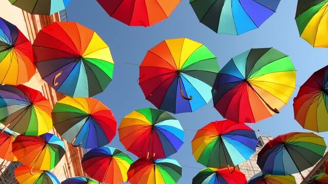 Video of colorful umbrellas hanging on the streets, very typical decorations in the magical towns of Mexico, panning to see all the LGBT-themed umbrellas recorded in Slow motion.
