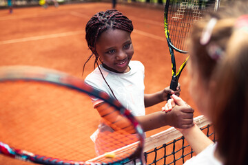 Little girl shaking hand with opponent after tennis match