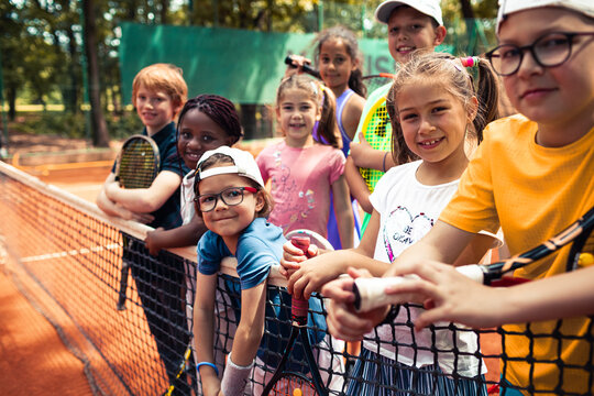 Portrait of diverse children on tennis clay court