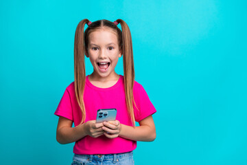 Portrait of astonished charming person open mouth hold apple iphone gadget isolated on turquoise...