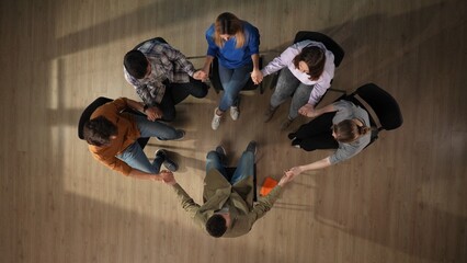In the frame above sits on a chair in the center, middle aged man, psychologist, mentor. Opposite...