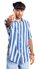 Young hispanic man wearing casual clothes pointing with finger up and angry expression, showing no gesture