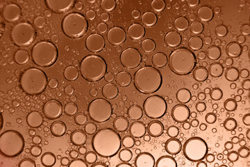 abstract light Peach Fuzz background with oil circles . bubbles of water close up
