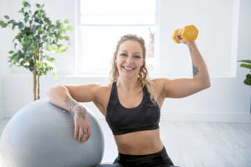 smiling woman with exercise ball in gym