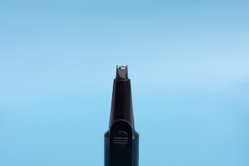 Closeup Electric Nose And Ear, Eyebrow, Facial Hair Trimmer On Blue Background. Removal Unwanted Hair Device. Personal Hygiene. Shaver, Epilator. Home Haircut Kit. Horizontal Plane