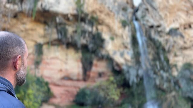 Mature man traveller overlooking  La Cueva Turche de Buñol  waterfall near Valencia
