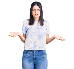Young beautiful girl wearing casual t shirt clueless and confused with open arms, no idea concept.