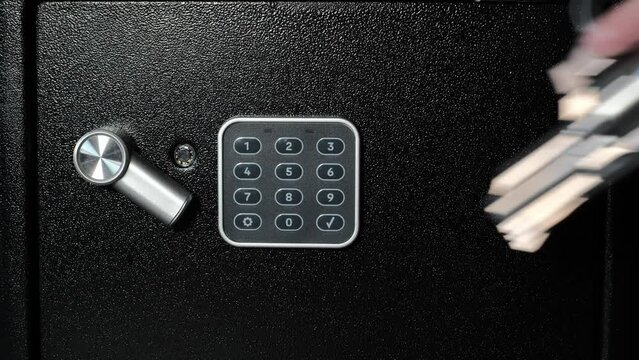 A criminal knocks on a safe using a revolver, the victim of the crime open the empty safe. A scene depicting a criminal robbery.
