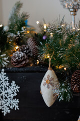 Christmas background with pine branch and beautiful yellow shiny bokeh. Wool pine cone. White snowflake. Shallow depth of field