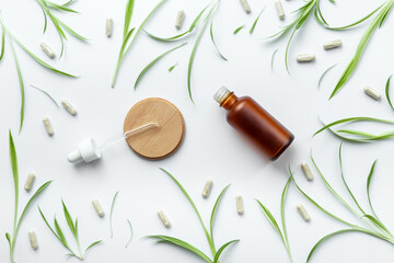 Herbal medicinal cosmetics - essential oil in a bottle with green leaves