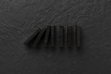 Black domino tiles on concrete background, top view - obrazy, fototapety, plakaty
