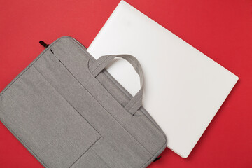 Grey stylish laptop bag with device on color background,top view