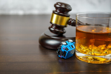 Judge's mace on a table in a court of law, glass of whiskey and miniature car. No drinking while...
