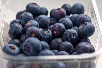 Fresh juicy blueberry berries in a plastic transparent supermarket pack