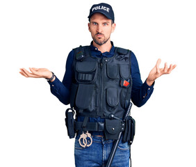 Young handsome man wearing police uniform clueless and confused with open arms, no idea concept.