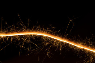 Festive abstract background for birthday, holiday with curved sparkler line on black backdrop....