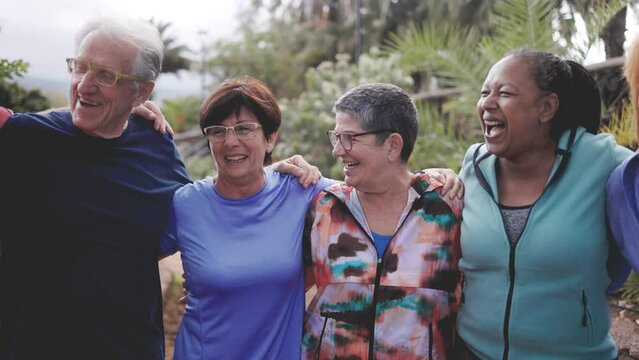 Diverse senior friends having fun after exercising outside in nature city park. Healthy lifestyle