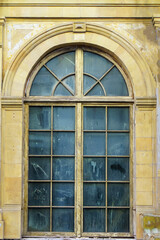 Large old window with arched top and dirty glass