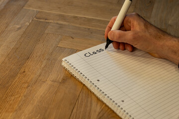 Blank notepad in class on wooden desk for mature student beginning learning in class. New subject for adult learning with handwritten notes and writing exercises for personal development