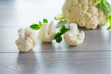 slices of raw small raw cauliflower on wooden table