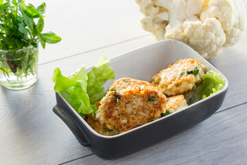 cooked vegetarian fried cauliflower cutlets in a ceramic form .
