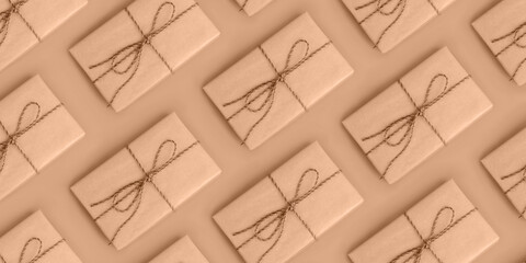 Background with color of the year -2024. Trendy color peach fuzz. Flat lay pattern of a gifts wrapped in paper and striped rope