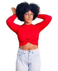 Young african american girl wearing casual clothes and glasses doing bunny ears gesture with hands...