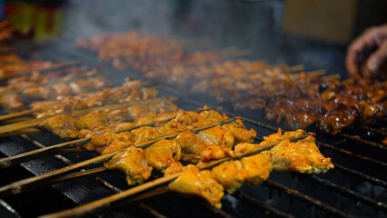 Chicken skewers grilled on a large grill. Season with spices. light yellow flesh There was a lot of smoke rising from the heat. Eat with sticky rice. Can be used as an illustration or background image